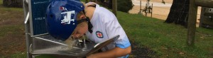 Young boy drinking from water fountain