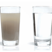 Full glass of tap water obscured by small particles. Concept for unhealthy water supply for people in developing countries.