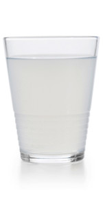 Full glass of tap water obscured by small particles. Concept for unhealthy water supply for people in developing countries.