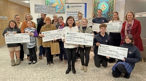 Community members holding their giant cheques for sponsorship of their local events and projects.